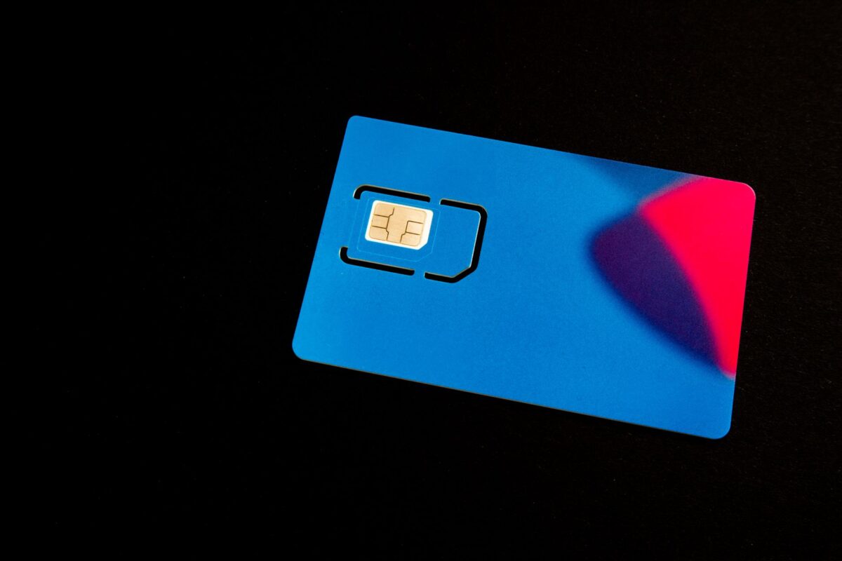 Carte SIM posée sur un fond sombre aux reflets colorés